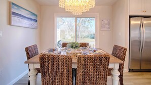 A dining area with a chandelier, a large window, and a stainless steel refrigerator. - Water Views, Access to Grand Cove! (Dennis)