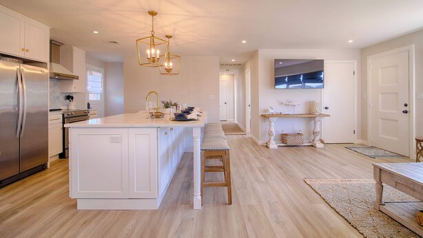 A modern kitchen with a central island, stainless steel appliances, and pendant lighting. - Water Views, Access to Grand Cove! (Dennis)