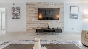 A modern living room with a fireplace, a console table, and artwork on the walls.