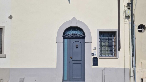 A building with a central arched door, a small window with shutters, and a mailbox. - Single-family home (Scandicci)