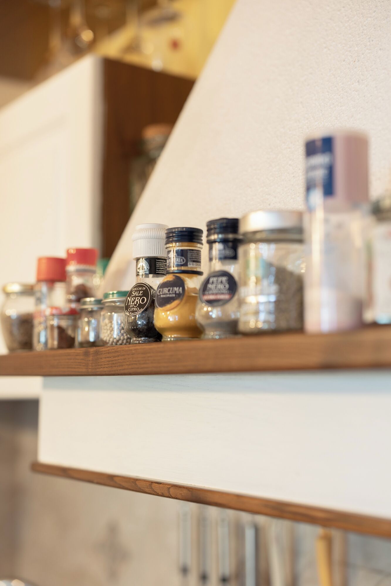Una estantería de cocina con botes y recipientes de especias.