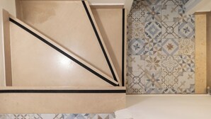 A tiled wall with geometric patterns and a plain beige section. - Single-family home (Scandicci)
