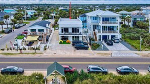 A coastal residential area with a two-story house featuring a balcony and a small deck.