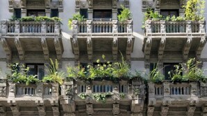 A building with ornate stone facades, multiple balconies with greenery, and a classical architectural style. - The Dream Suites (Milan)