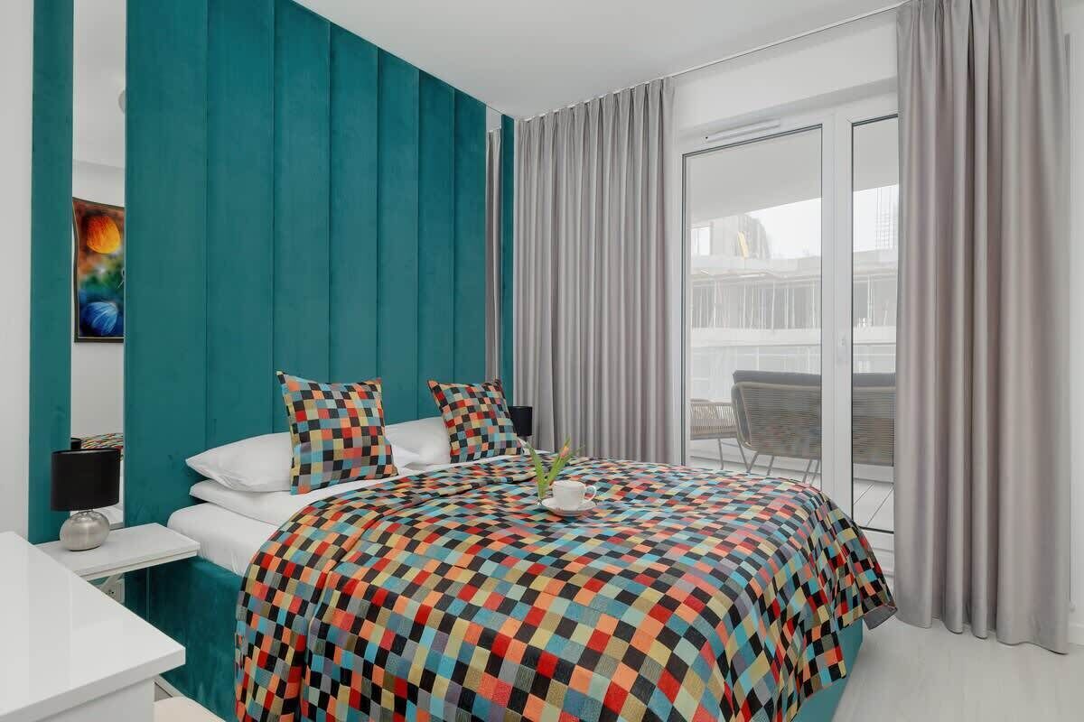 Een moderne hotelkamer met een groot bed, een bureau en uitzicht op de stad door het raam.