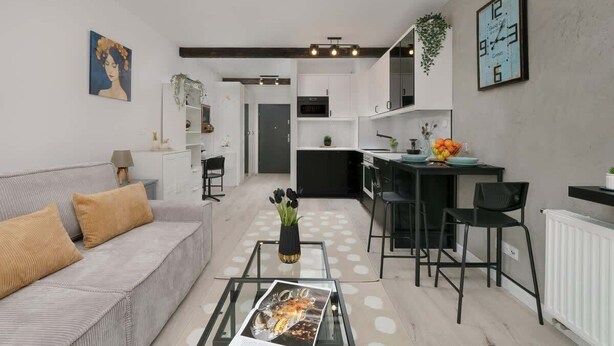 Una sala de estar moderna con un sofá, una mesa de centro y un comedor con sillas y una mesa.