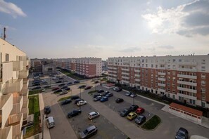 Un immeuble résidentiel à plusieurs étages avec un parking situé à l’avant.