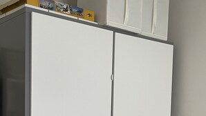 Un armario blanco con varios compartimentos y un tirador.