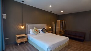 Un dormitorio moderno con una cama grande, mesitas de noche de madera y un banco.