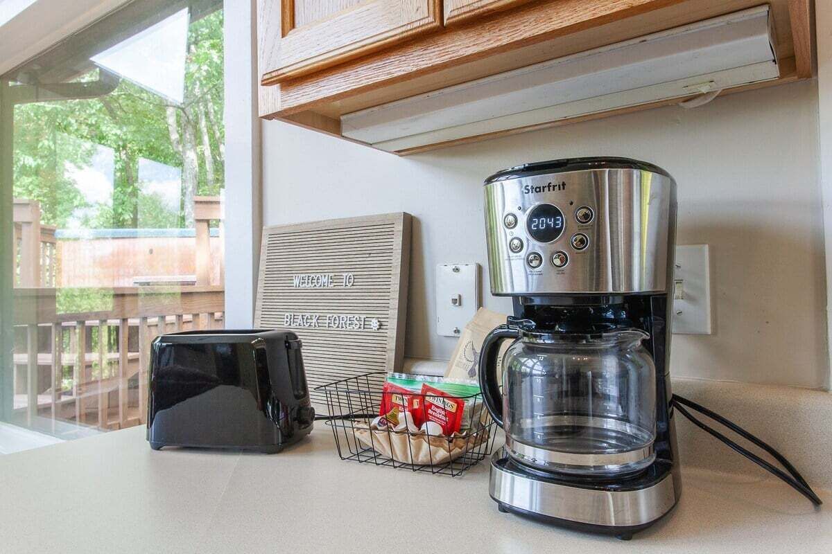 En Starfrit-kaffebryggare står på en köksbänk tillsammans med en brödrost och en korg med kaffekapslar.