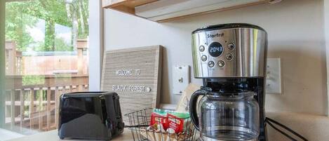 En Starfrit-kaffebryggare står på en köksbänk tillsammans med en brödrost och en korg med kaffekapslar.