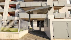 A multi-story residential building with balconies, a gated entrance, and a small garden area. - Stunning 1-bed Apartment in Verona (Verona)