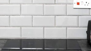 A kitchen with white subway tiles, a black induction cooktop, and a stainless steel range hood. - Flat 2 Covent Garden Apartments

 (London)