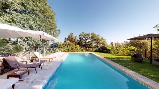 A swimming pool with lounge chairs and umbrellas, surrounded by greenery and trees. - Abejas 2 El Vergel de Chilla (Candeleda)