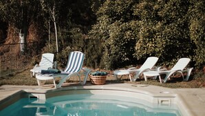 Ein Swimmingpool mit Liegestühlen und einem Korb.