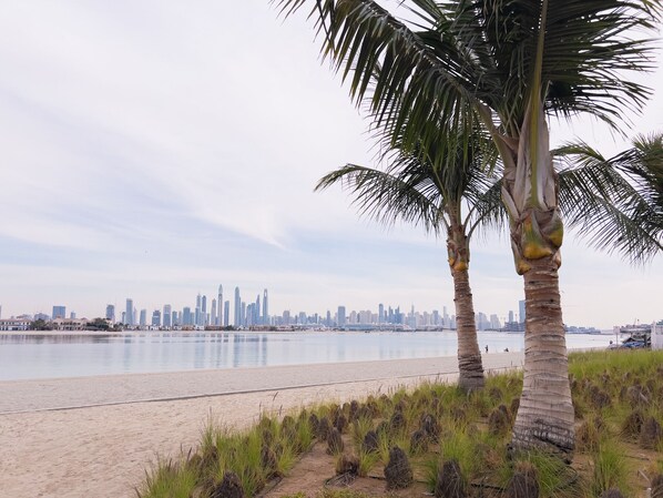 On the beach, white sand, beach umbrellas, beach towels - Palm Perfection 3BR with Private Beach (Dubai)