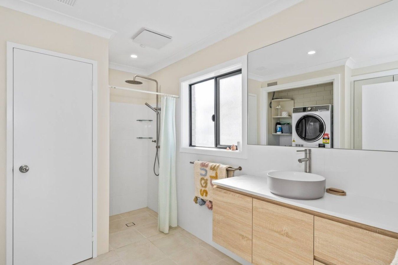 A modern bathroom with a shower, a sink, and a mirror.