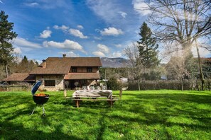 A house with a stone facade, a tiled roof, and a barbecue grill in the yard. - The Basque Experience by Fidalsa (Otxandio)