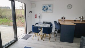 Eine moderne Küche mit Essbereich, einem großen Fenster und Blick ins Freie.