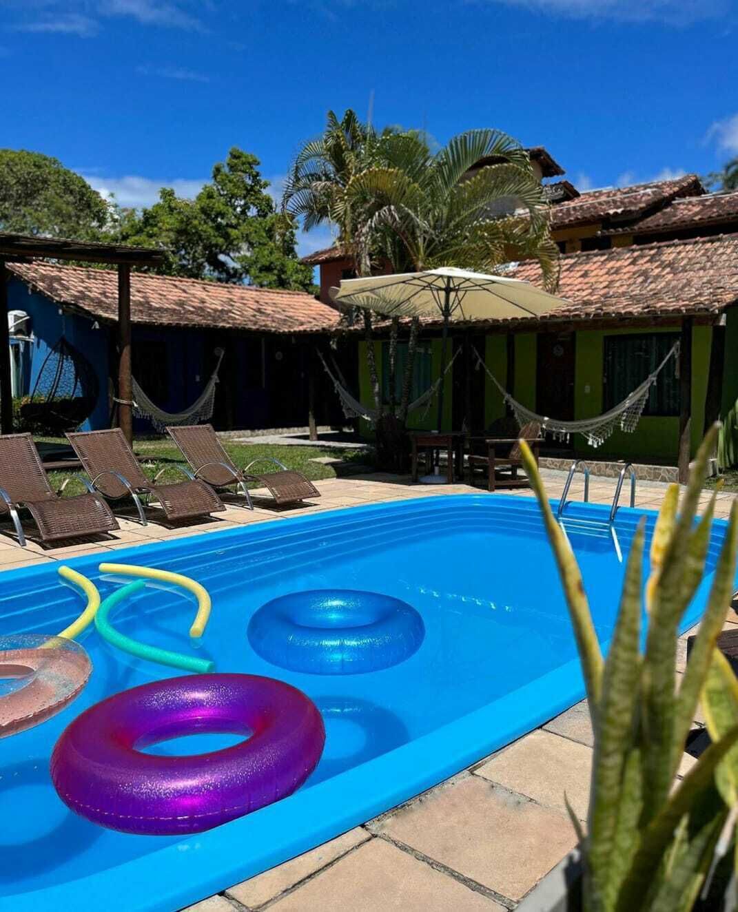 A swimming pool with lounge chairs and a hammock.