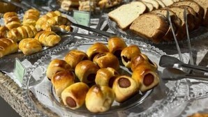 A buffet with various food items including bread, pastries, and a selection of vegetables. - Pousada Tropicália (Porto Seguro)