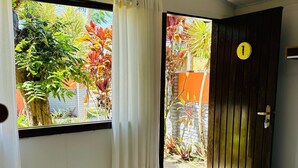 A room with a large window, a door with a number, and a tiled floor. - Pousada Tropicália (Porto Seguro)