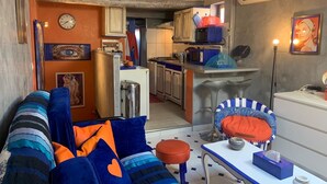 A compact living space with a sofa, a small table, and a kitchenette. - Appartement de Luxe au Cœur D'aix-en-provence (Aix-en-Provence)