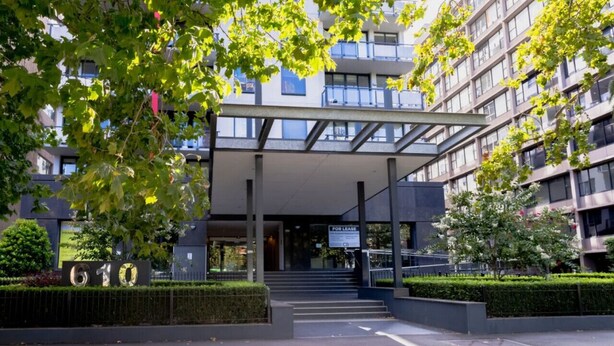A modern building with a covered entrance, steps leading up to the entrance, and a sign indicating availability for lease. - St Kilda Rd Gem | Prime Spot (Melbourne)