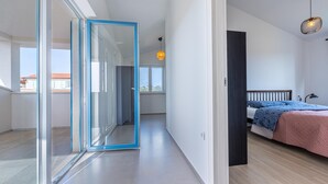 Une chambre à coucher moderne avec un lit, une table de chevet et un grand miroir.