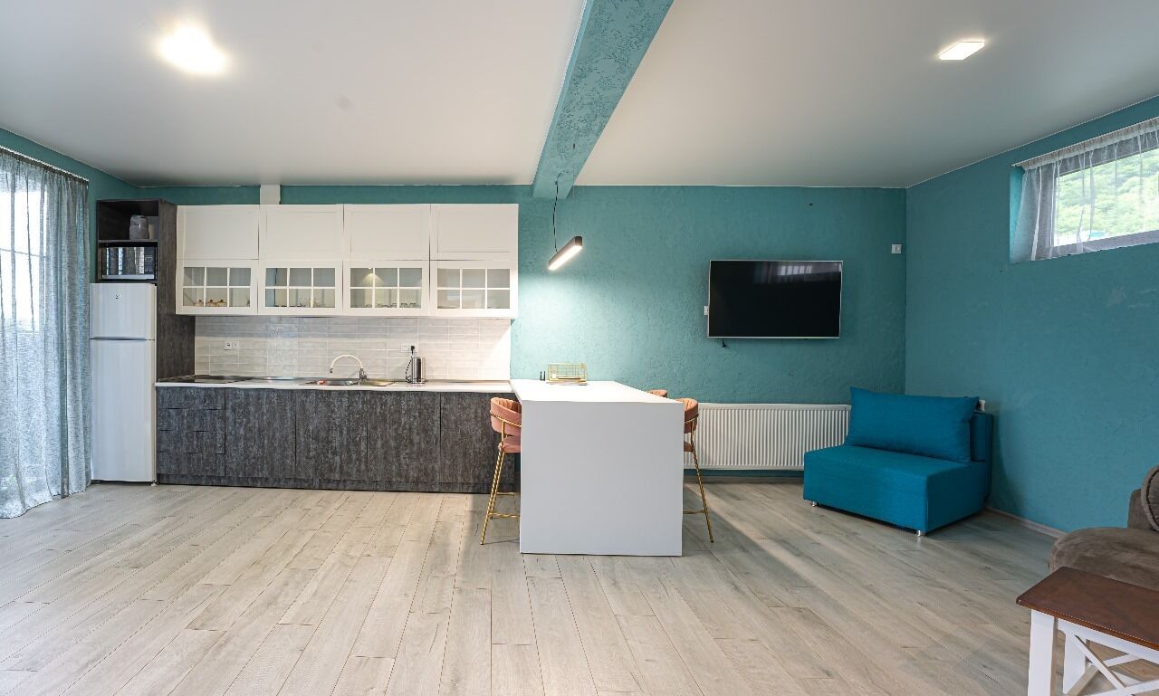 A modern living space with a kitchen, dining area, and seating area.