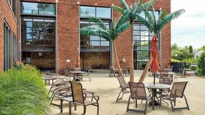 An outdoor patio with brick walls, large windows, and outdoor seating.