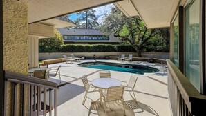 A covered outdoor area with a swimming pool, lounge chairs, and a table. - 2 Duck Hawk - Sea Pines just a Short Walk to the Beach & Private Pool (Hilton Head Island)