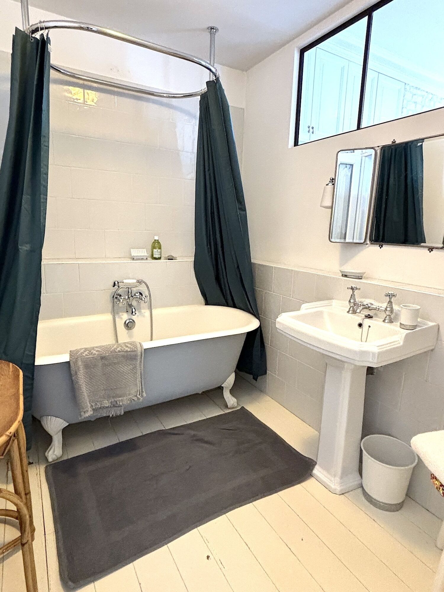 A bathroom with a bathtub, a sink, and a mirror.