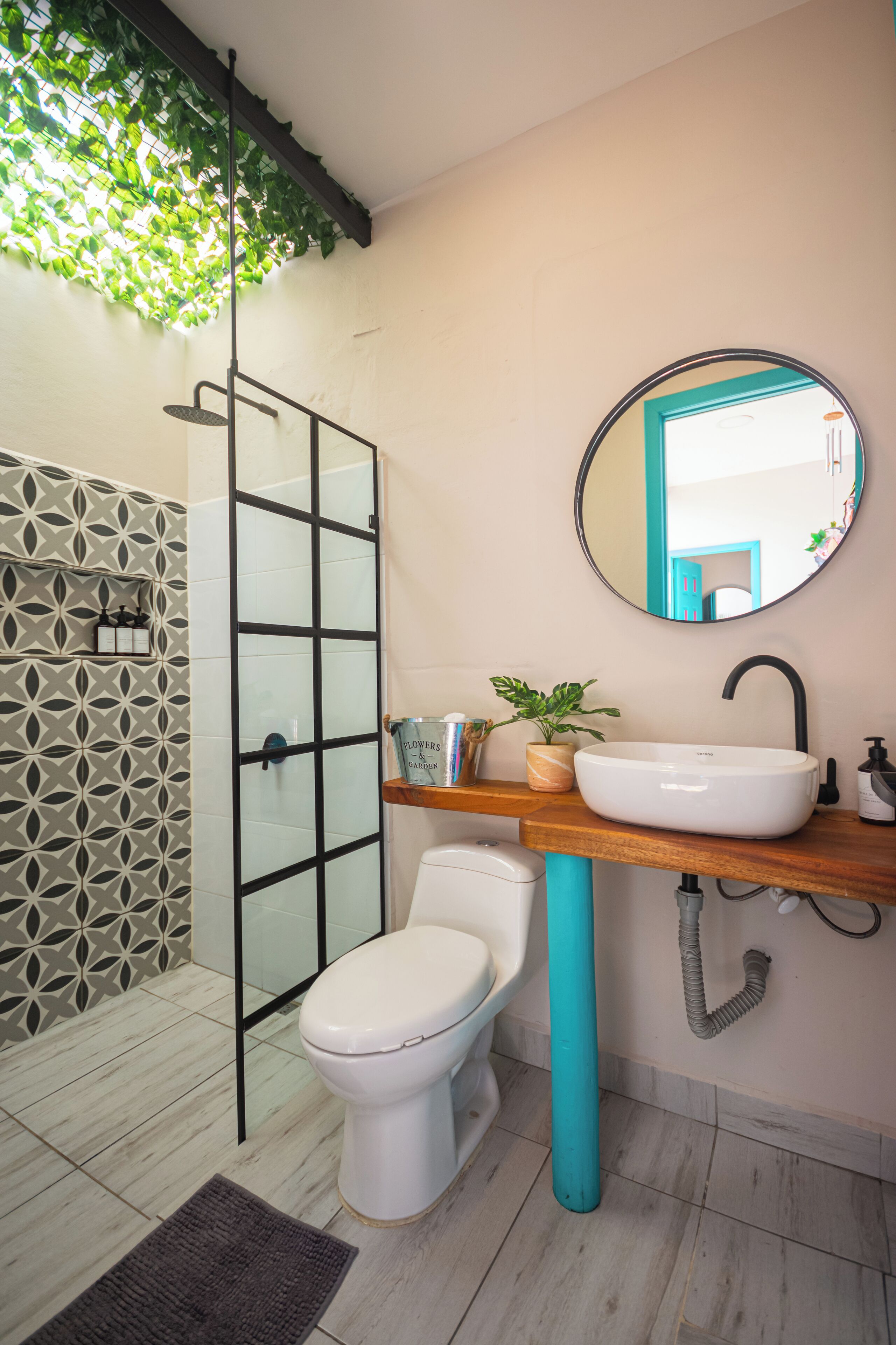 Ein Badezimmer mit einer weißen Toilette, einem Waschbecken mit Spiegel darüber und einer Dusche mit Glastür.