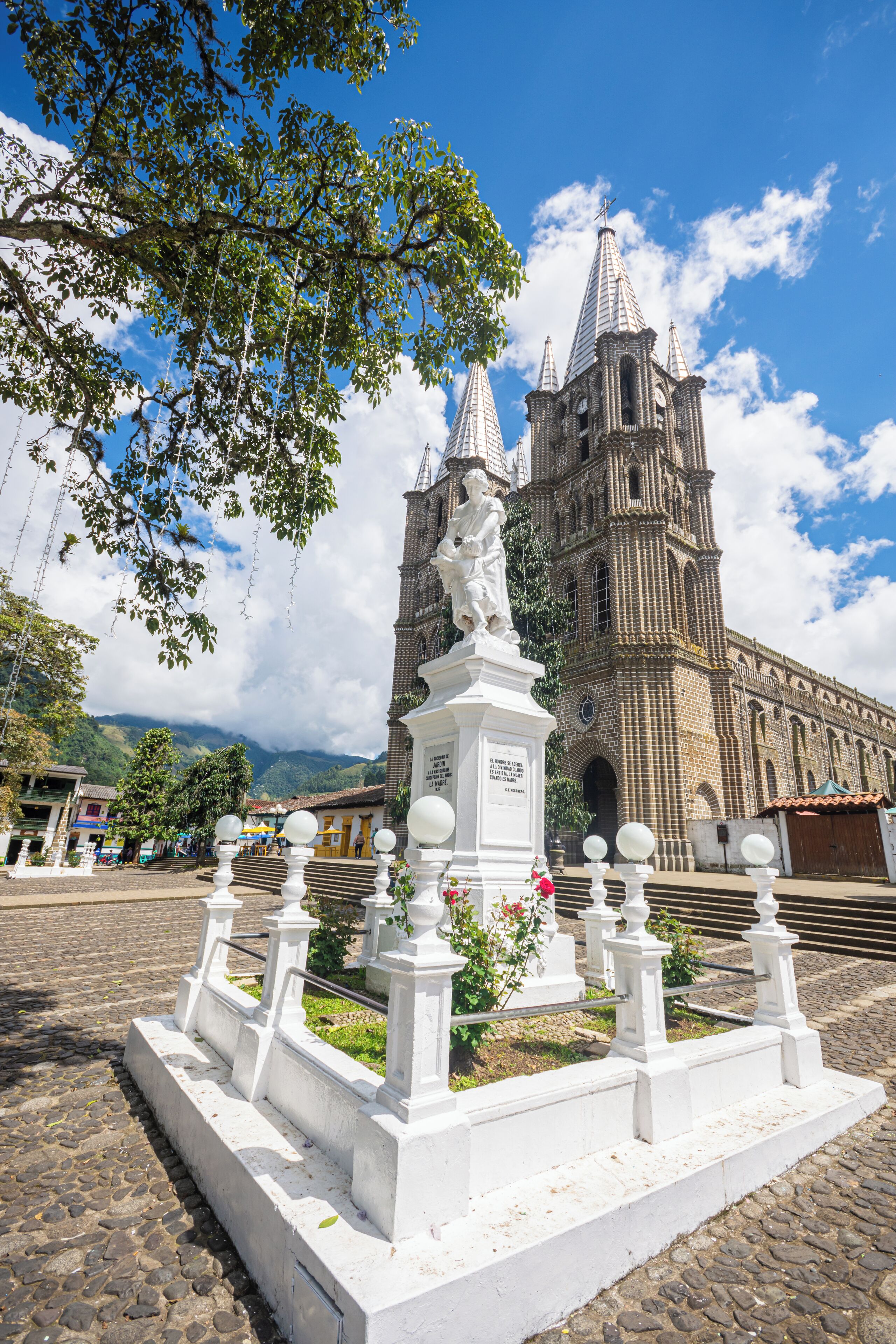Una iglesia histórica con un campanario y una estatua en primer plano.