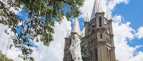 Una iglesia histórica con un campanario y una estatua en primer plano.