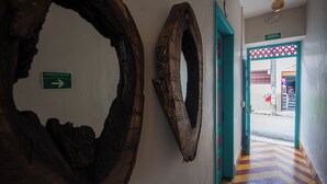 A hallway with rustic wooden wall decorations and a directional sign. - CASA HOTEL LAS HORTENSIAS (Jardin)