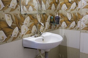 A bathroom with a sink, mirror, and wall-mounted dispenser. - TRPOTEL SUBMANGAL (Gwalior)