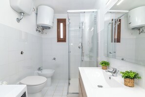 Een douche, een bidet, handdoeken, zeep