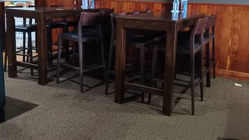A restaurant with wooden booths and tables, a TV screen displaying a sports event, and posters on the wall.