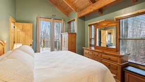Un dormitorio con una cama grande, cómoda de madera y un espejo.