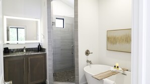 Une salle de bain moderne équipée d’une douche, d’une baignoire et d’un meuble-lavabo avec un miroir.