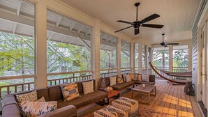 A covered porch with a wooden deck, a sofa set, ottomans, and a hammock. - Seabbatical at WaterColor|Private Community Beach Access|On Western Lake (WaterColor)
