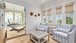 A spacious living room with a hammock, a striped sofa, and a coffee table. - Seabbatical at WaterColor|Private Community Beach Access|On Western Lake (WaterColor)
