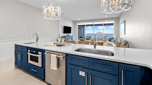 Una cocina moderna con una isla grande, electrodomésticos de acero inoxidable y armarios azules.