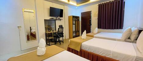 A hotel room with two beds, a desk, a chair, a television, and a mirror.