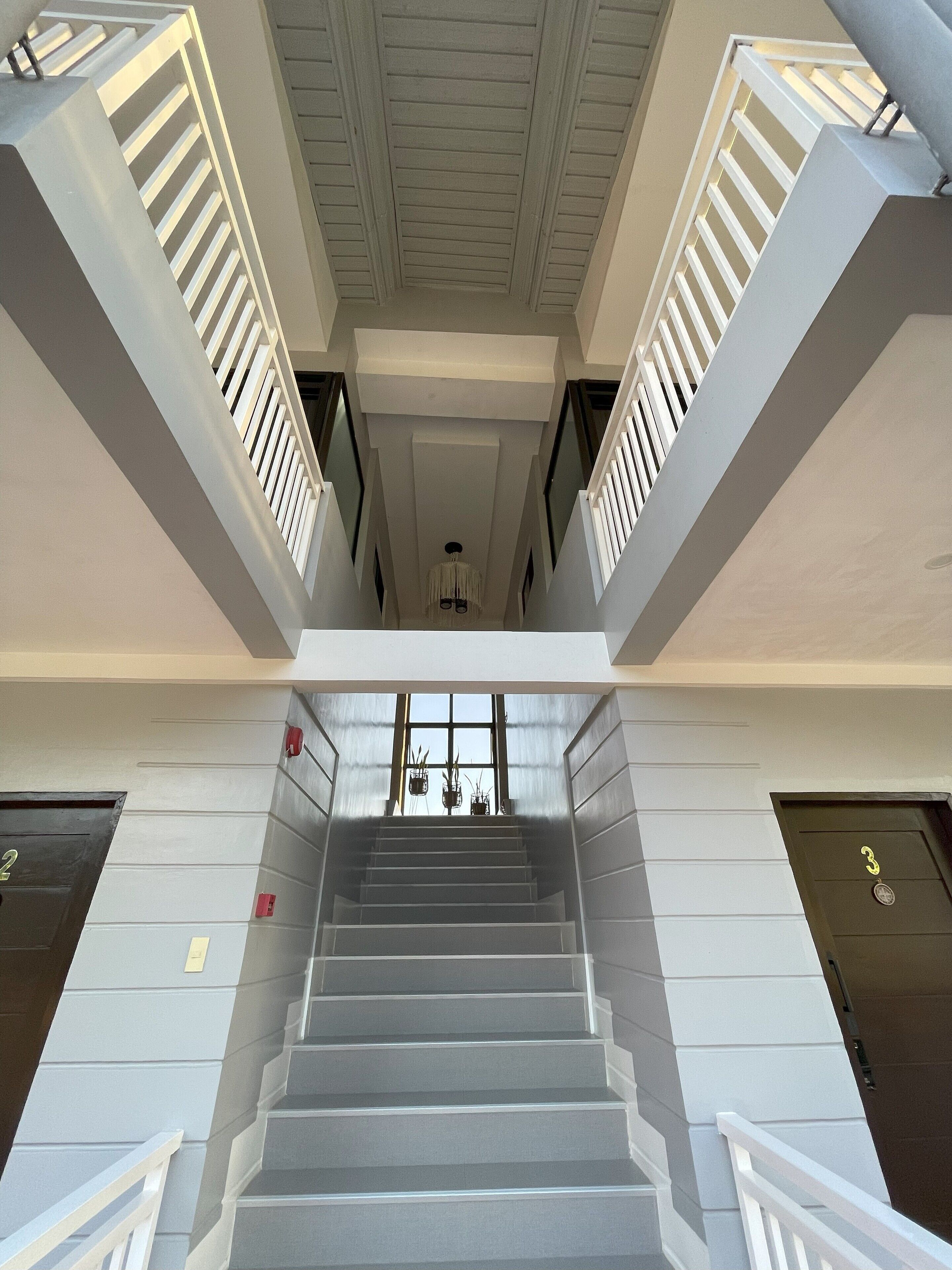 A staircase with white railings and a view of the interior.
