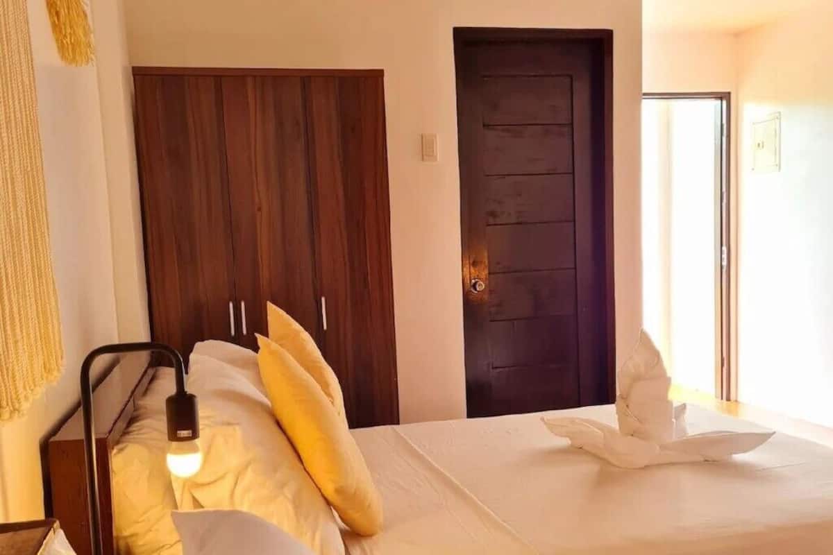 Een hotelkamer met twee bedden, een houten kast en een deur.