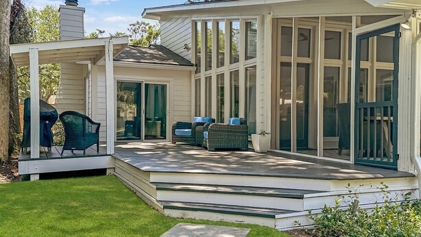 A house with a covered patio, outdoor seating, and a screened porch. - 4 BR IOP Beach Rental with Private Pool & Hot Tub (Isle of Palms)