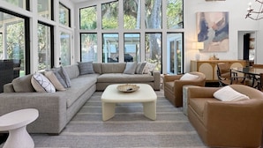 A spacious living room with a sectional sofa, a coffee table, and a dining area. - 4 BR IOP Beach Rental with Private Pool & Hot Tub (Isle of Palms)